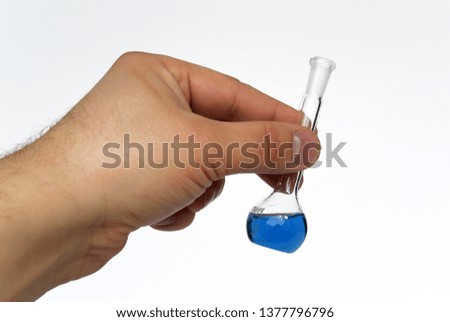 Photograph of a medical background with test tubes and cones for chemical experiments with a multi-colored liquid in hand