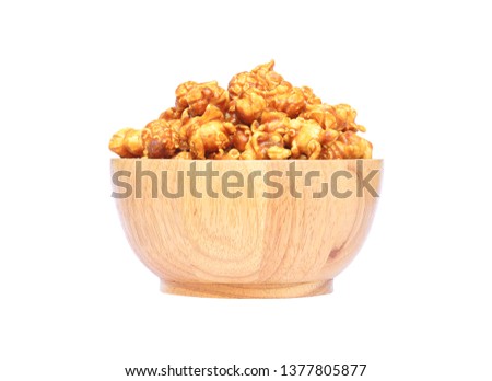 Popcorn with caramel in a wooden bowl isolated on white background with clipping path.

