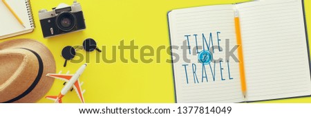 Top view photo of traveling concept with accessories over yellow background