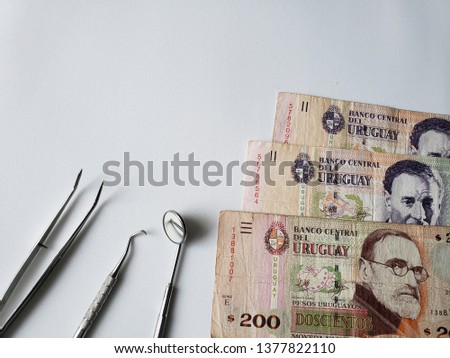 dentist utensils for oral review and uruguayan banknotes 