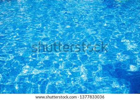 Blue clear water in swimming pool. Rippled water surface. Abstract background.