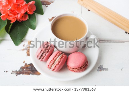 Cup of coffee and macaroon cookies on a plate on a white background. copy space.
