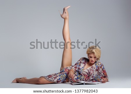 Beautiful, pretty girl blonde with blue eyes with a crega in her hands, studio shot