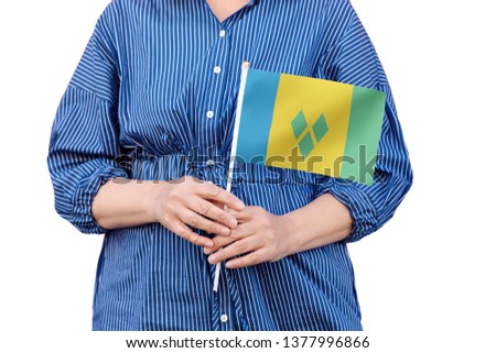 Saint Vincent and the Grenadines flag. Close up of woman's hands holding a national flag of St Vincent isolated on white background.