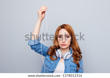 Close up photo beautiful she her lady hold arm hand earflaps can not turn on listen favorite audio songs playlist lose smart phone mobile wear casual blue jeans denim shirt isolated grey background