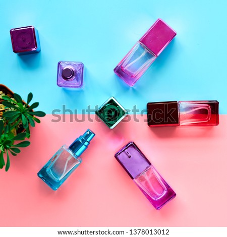 Colorful cosmetic spray bottles on pink and sky blue background. Aroma flat lay design with copy space