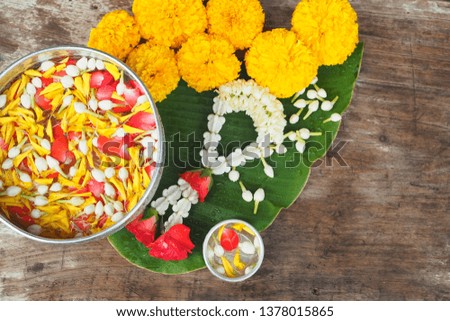 Thai traditional jasmine garland and colorful flower in water, on Banana leaf for Songkran Festival or Thai New Year. Royalty-Free Stock Photo #1378015865