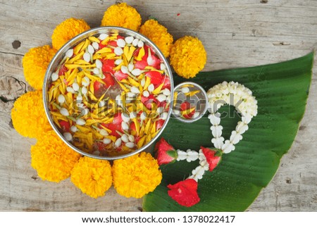 Thai traditional jasmine garland and colorful flower in water, on Banana leaf for Songkran Festival or Thai New Year. Royalty-Free Stock Photo #1378022417