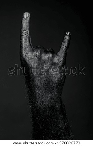 Rock and metal, full black hand shows goat sign. Vertical frame