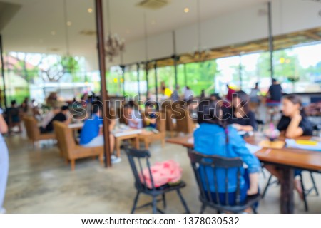 Blurred background group of people sitting in cafe sunny day
