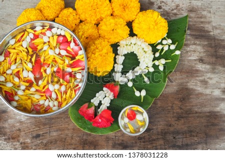 Thai traditional jasmine garland and colorful flower in water, on Banana leaf for Songkran Festival or Thai New Year. Royalty-Free Stock Photo #1378031228