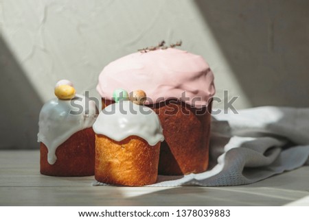 Happy Easter background with an easter bread cake decorated with glaze, chocolate and  eggs. For greeting card, ad, promotion, poster, flyer. complex composition, beautiful scenery, movement, hands