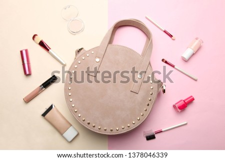 Stylish fashionable round handbag and different women's cosmetics on beige and pink background. Concept accessory, beauty. Top view.