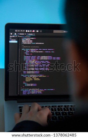 Programmer working on laptop computer in office