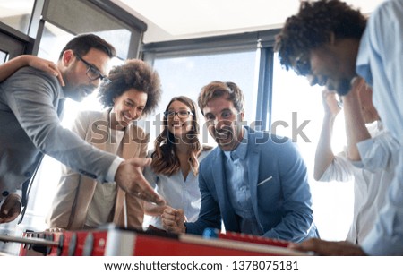 Multicultural business people celebrating win while playing table football