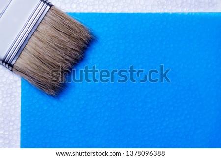 business card company building materials, repair. paint brush for construction paint isolated on blue 
 background. concept of building materials. suitable for design, cutaway, website, billboard