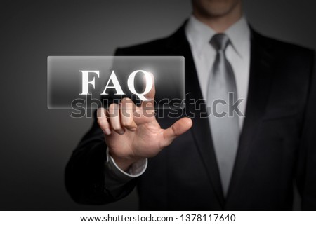 business, technology, internet, network concept - businessman in suit presses virtual touchscreen button - english word FAQ (frequently asked questions)