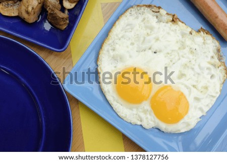 double sunny side up fried eggs with sausages on a beautiful modern plate for breakfast