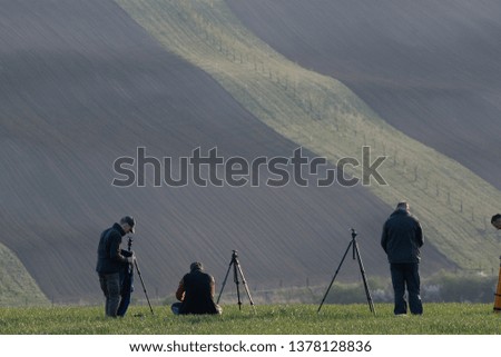 Student and lectors of photography in action. Photographers are taking pictures of agriculture landscapes in europian fields
