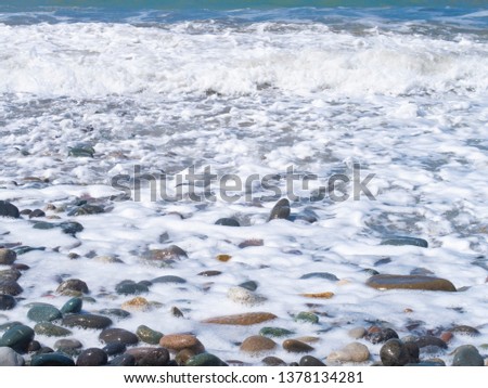background of seafoam flowing over the stones