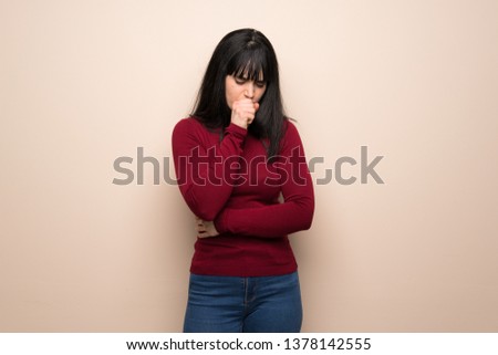Young woman with red turtleneck is suffering with cough and feeling bad