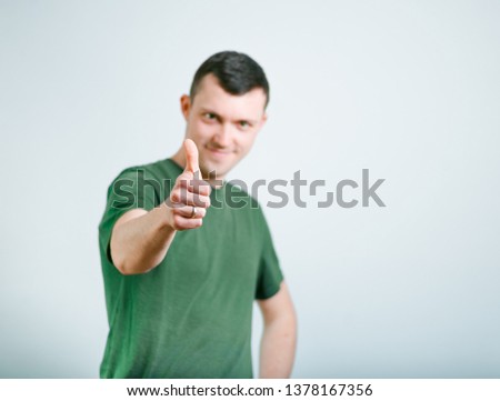 successful man shows sign like, thumb up, studio photo over background