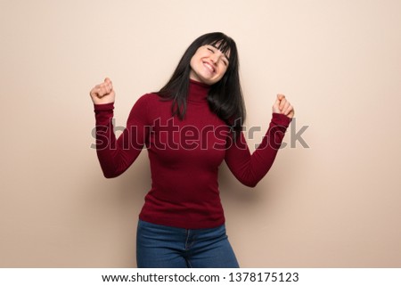 Young woman with red turtleneck enjoy dancing while listening to music at a party