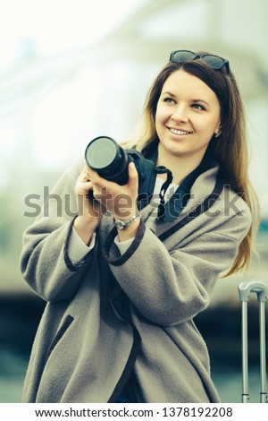 Young girl taking picture with her camera in the town