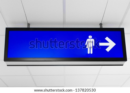 Blue public sign showing unisex toilet directions
