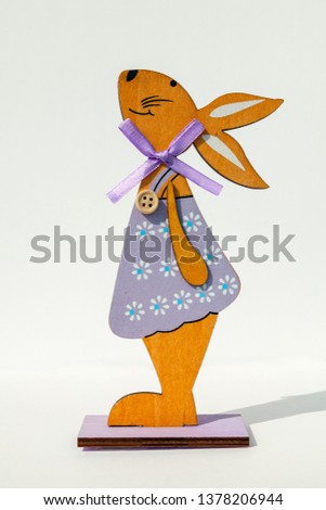 Figure from wood. Silhouette of a dressed bunny, isolated in white background
