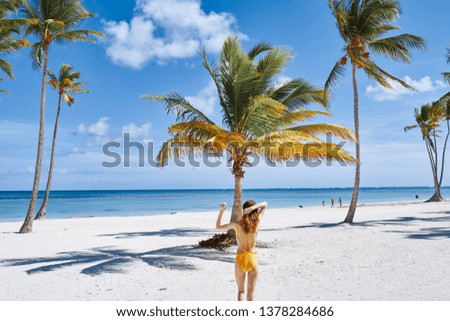A woman in a yellow swimsuit beach vacation ocean relax exotic