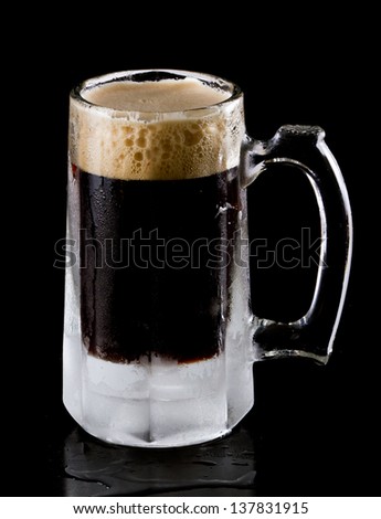 frozen mug with a stout style beer isolated on a black background