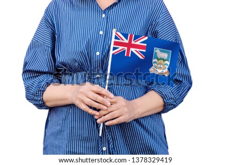 Falkland Islands flag. Close up of woman's hands holding a national flag of Falkland Islands isolated on white background.
