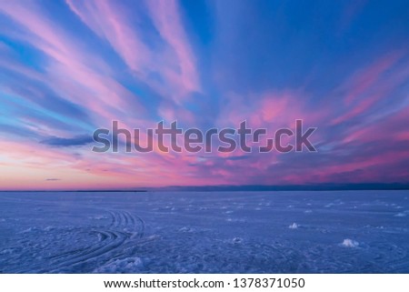 purple blue sunset or sunrise in winter over the river in ice