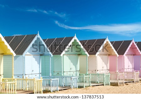 Traditional British beach huts on a bright sunny day Royalty-Free Stock Photo #137837513