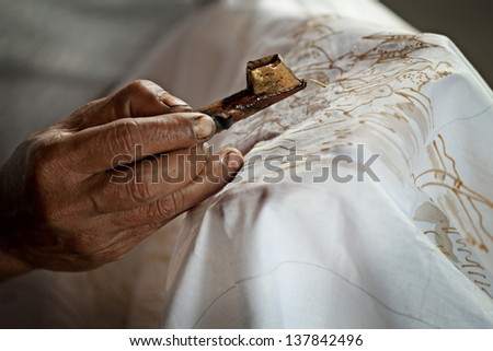 Batik painting on a white cloth process close up. Indonesia Royalty-Free Stock Photo #137842496