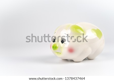Sad White green and pink piggy back in front of white background.