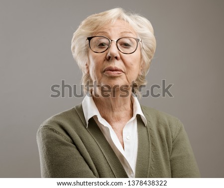 Confident senior lady looking at camera with disdain Royalty-Free Stock Photo #1378438322