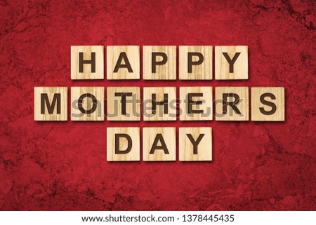 Happy Mother's Day, word written on wooden blocks. Red background Congratulatory background. Holiday card. Festive background.