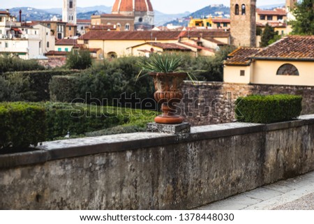 View of Boboli Gardens in Florence, Italy, with sculptures, blooming trees and flowers.
