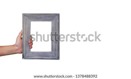 Female hand holding a wooden frame isolated on white background. close up.