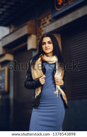 A stylish and beautiful girl standing in a summer city