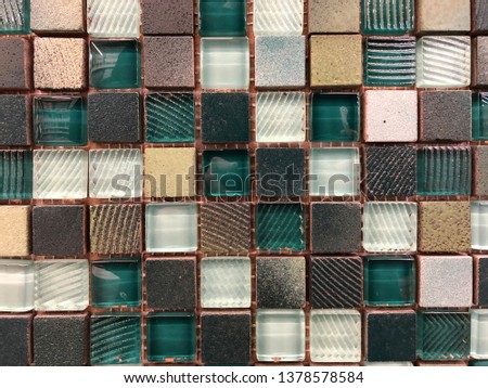 Glass mosaic in the form of small squares on a synthetic mesh. Two shades of glass mosaic with different transparency and density.