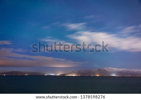 Green Northern lights over sea and mountains in Reykjavic, Iceland