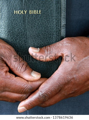 black man holding the Holy Bible after praying in church with people stock image and stock photo Royalty-Free Stock Photo #1378619636