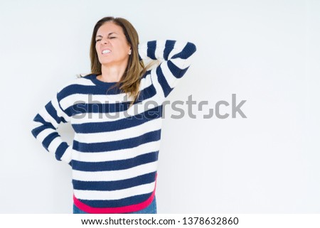 Beautiful middle age woman wearing navy sweater over isolated background Suffering of neck ache injury, touching neck with hand, muscular pain