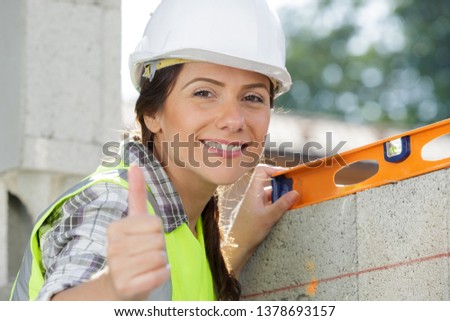 female mason showing thumb-up