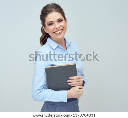 portrait of happy woman wearing blue shirt holding book. 