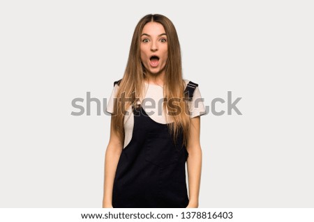 Young pretty woman with surprise and shocked facial expression on isolated grey background