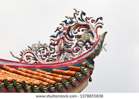 Giant grand colorful Chinese dragon porcelain roof tile in isolate bright natural blue sky background